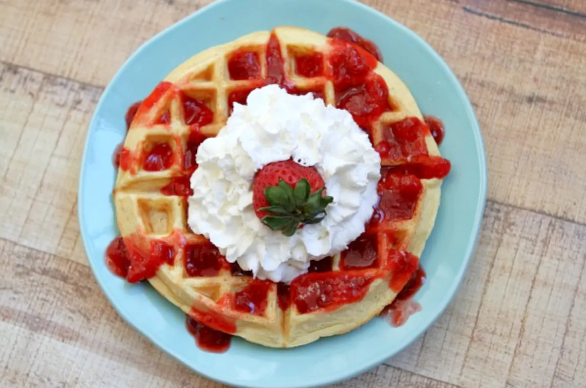waffle with strawberry sauce and whipped cream