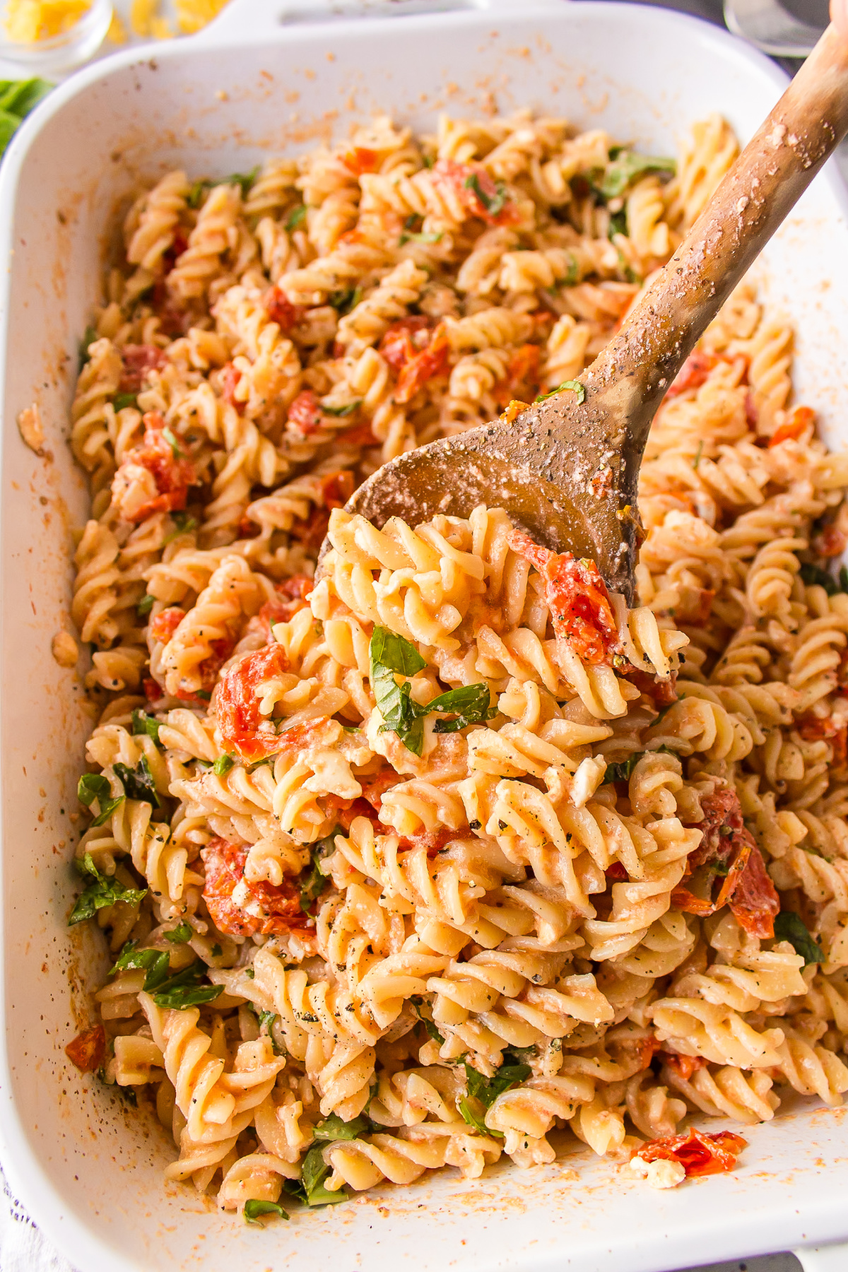 casserole dish of tik tok baked feta pasta with wooden spoon