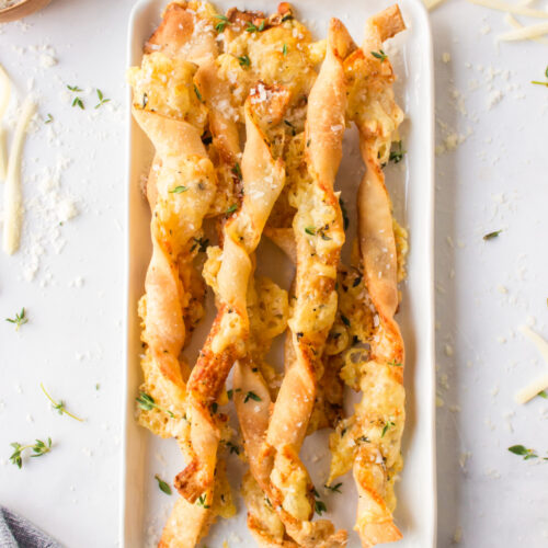 cheese straws displayed on white dish