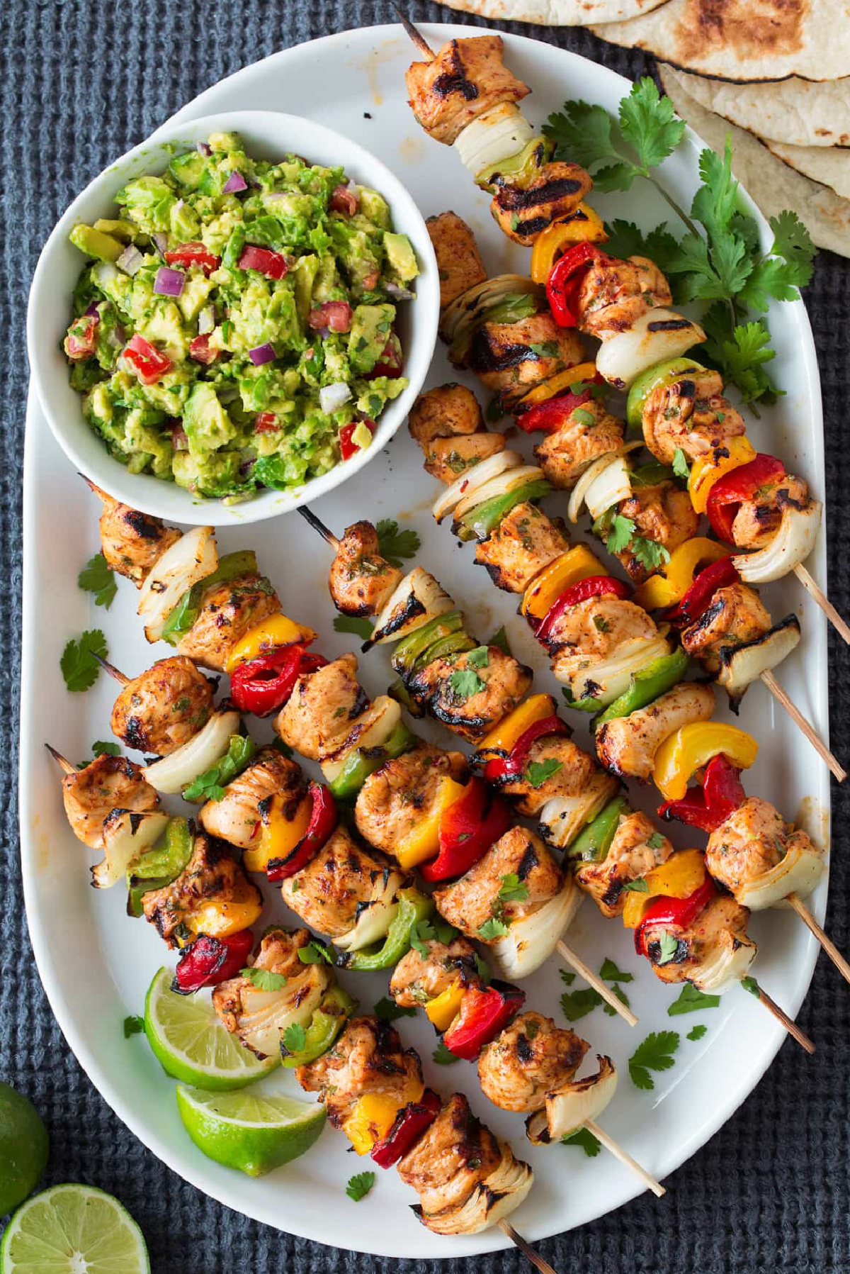 grilled fajita kebabs on platter with guacamole bowl