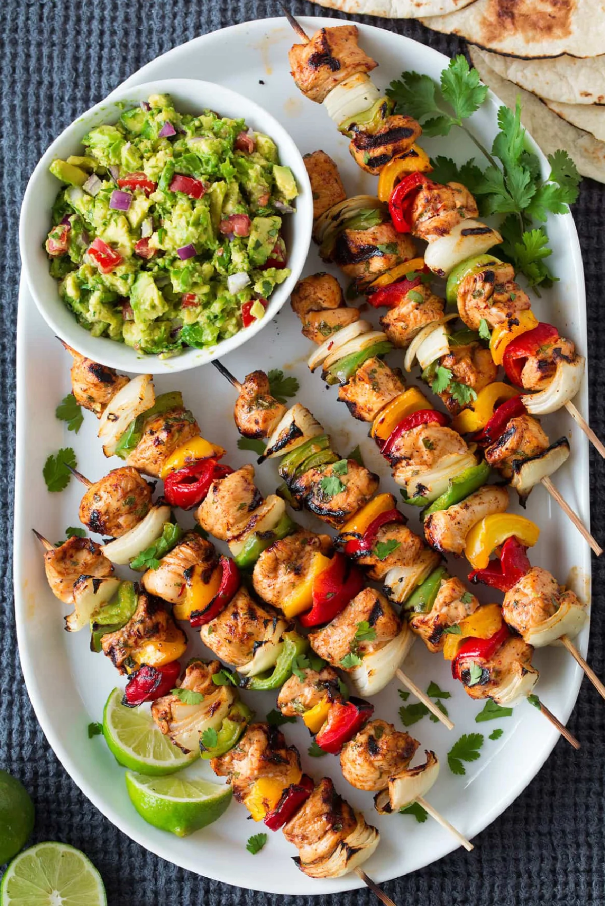 grilled fajita kebabs on platter with guacamole bowl