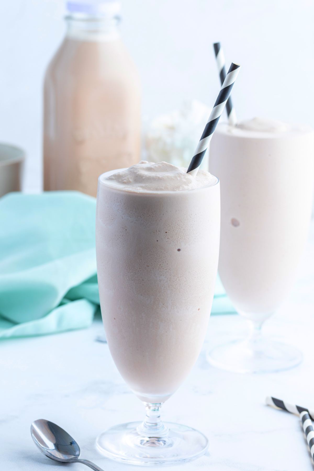 glasses of copycat wendy's chocolate frosty with chocolate milk in background