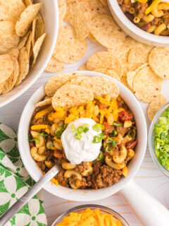 beef chili mac in bowl with sour cream