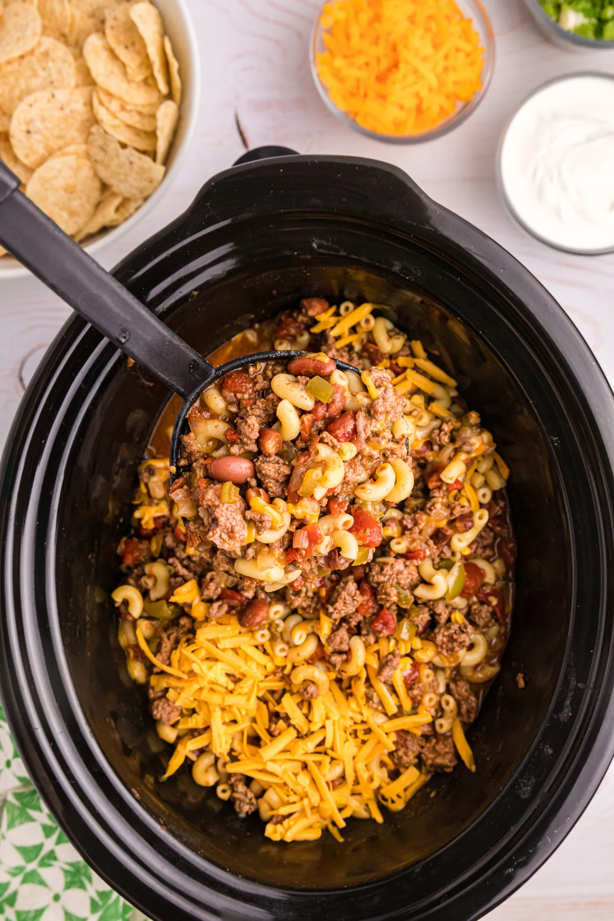 beef chili mac in the slow cooker insert with cheese