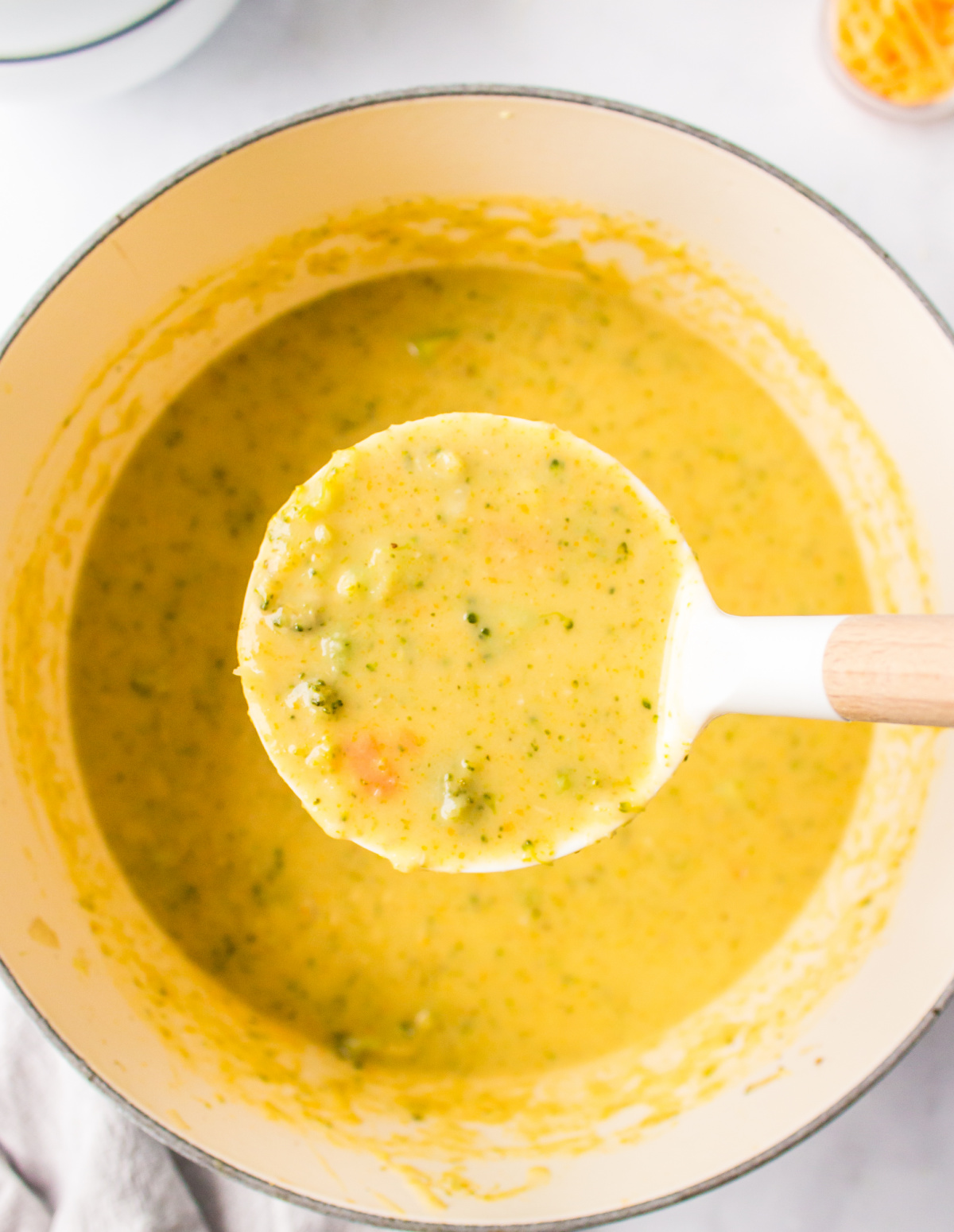 ladle full of 20 minute broccoli cheese soup over pot