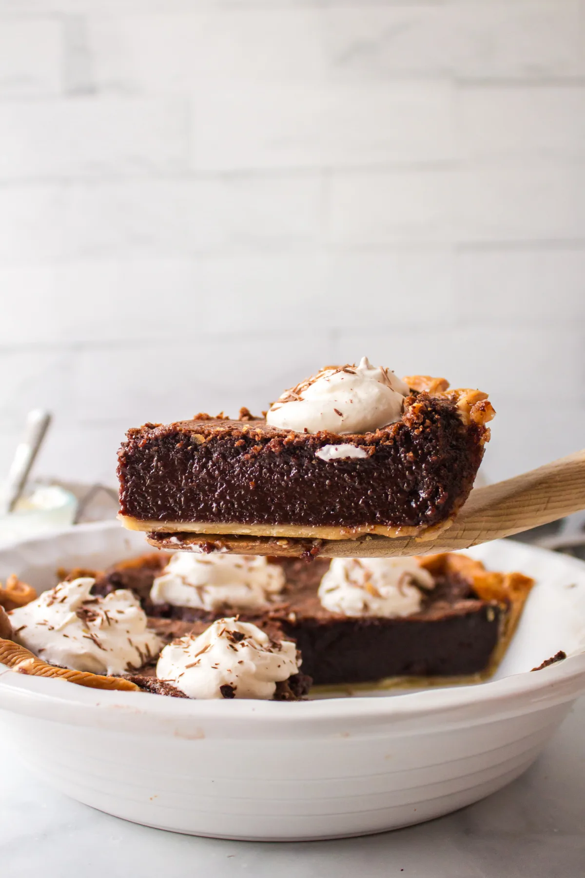 spatula holding slice of chocolate chess pie