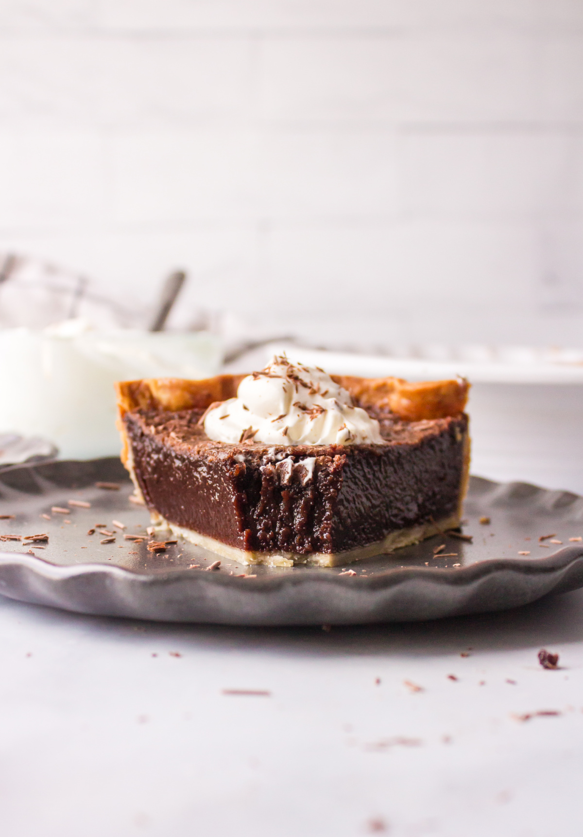 slice of chocolate chess pie on plate with bite taken out of it