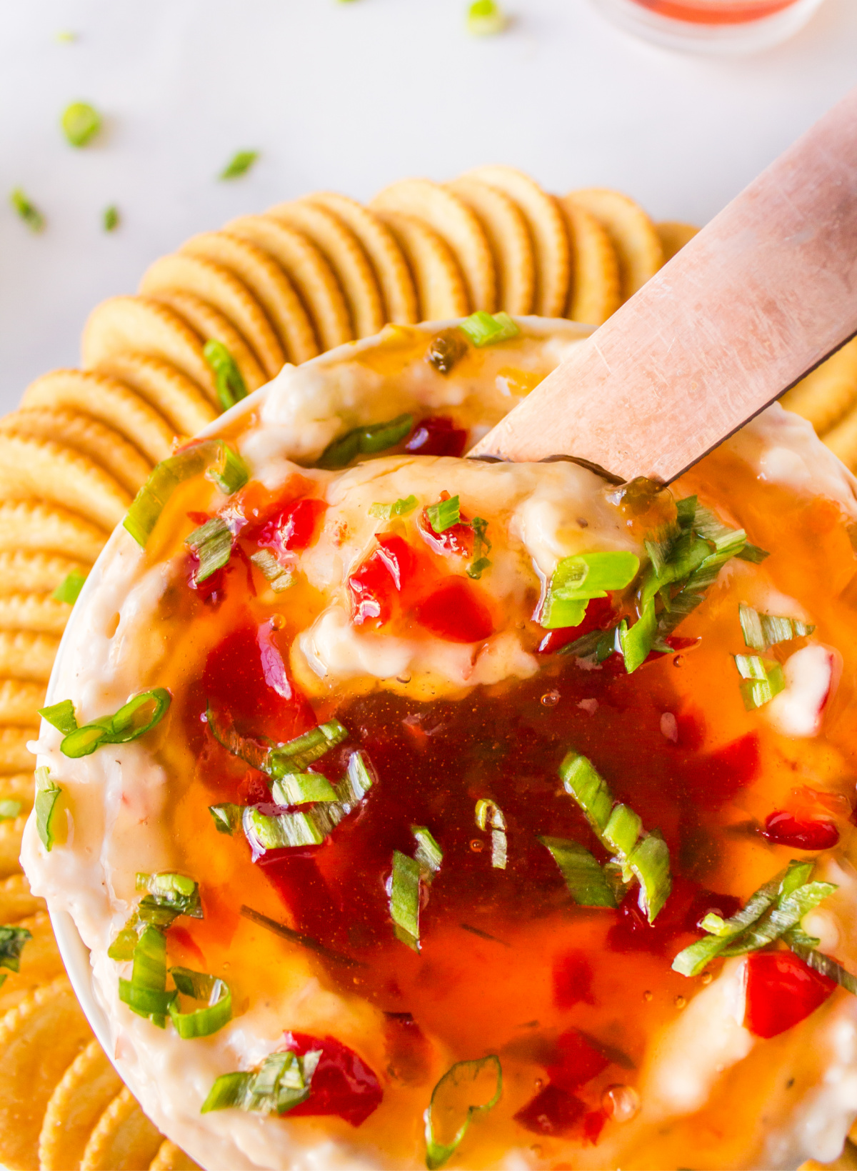 knife sticking into pepper jelly cream cheese dip