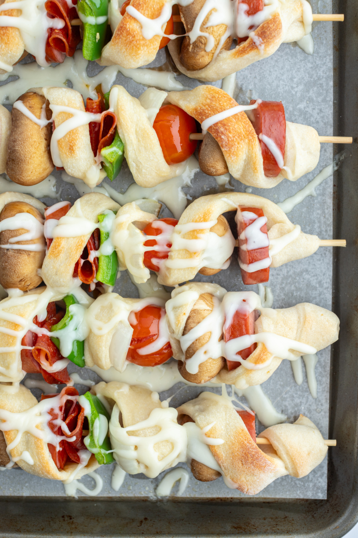 close up pizza kabobs on baking sheet