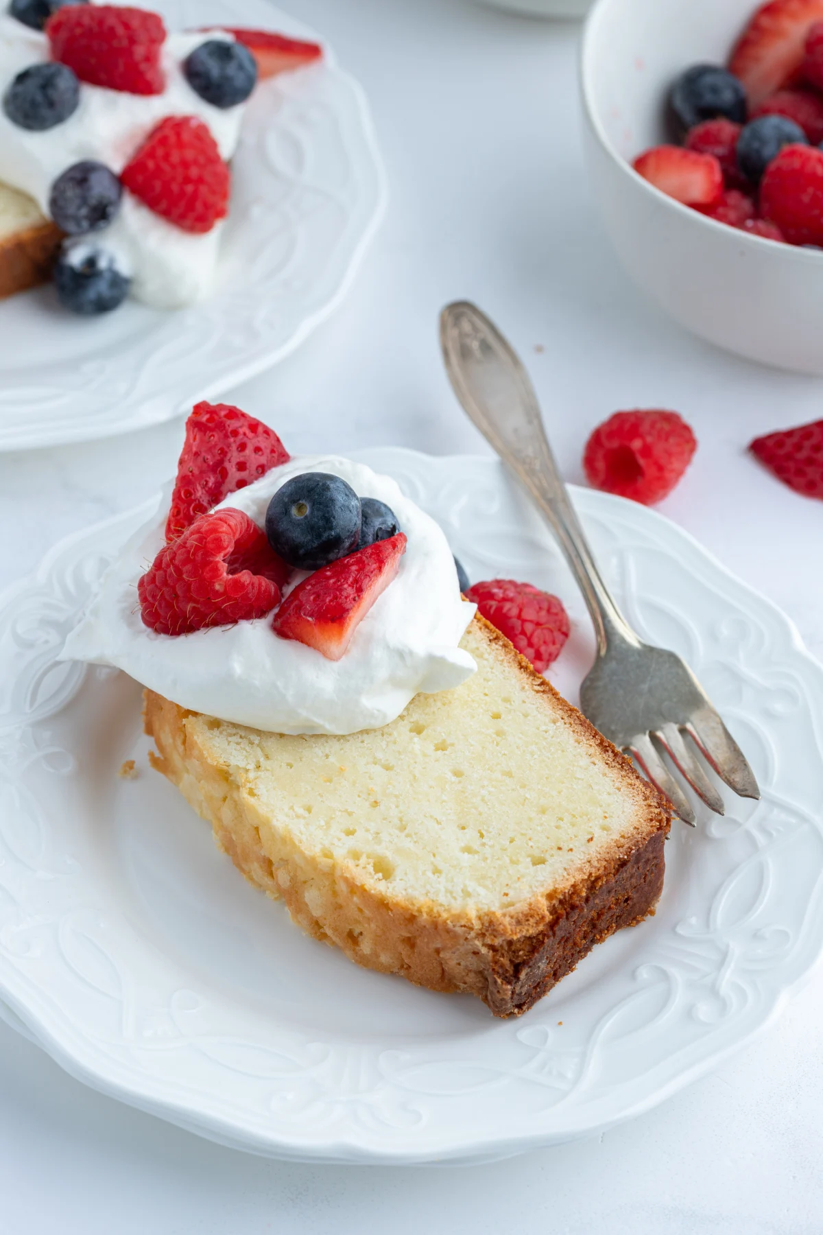 slice of pound cake topped with whipped cream and fruit