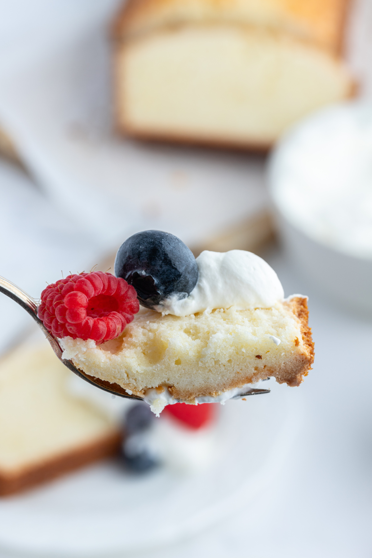 fork full of pound cake with whipped cream and fruit