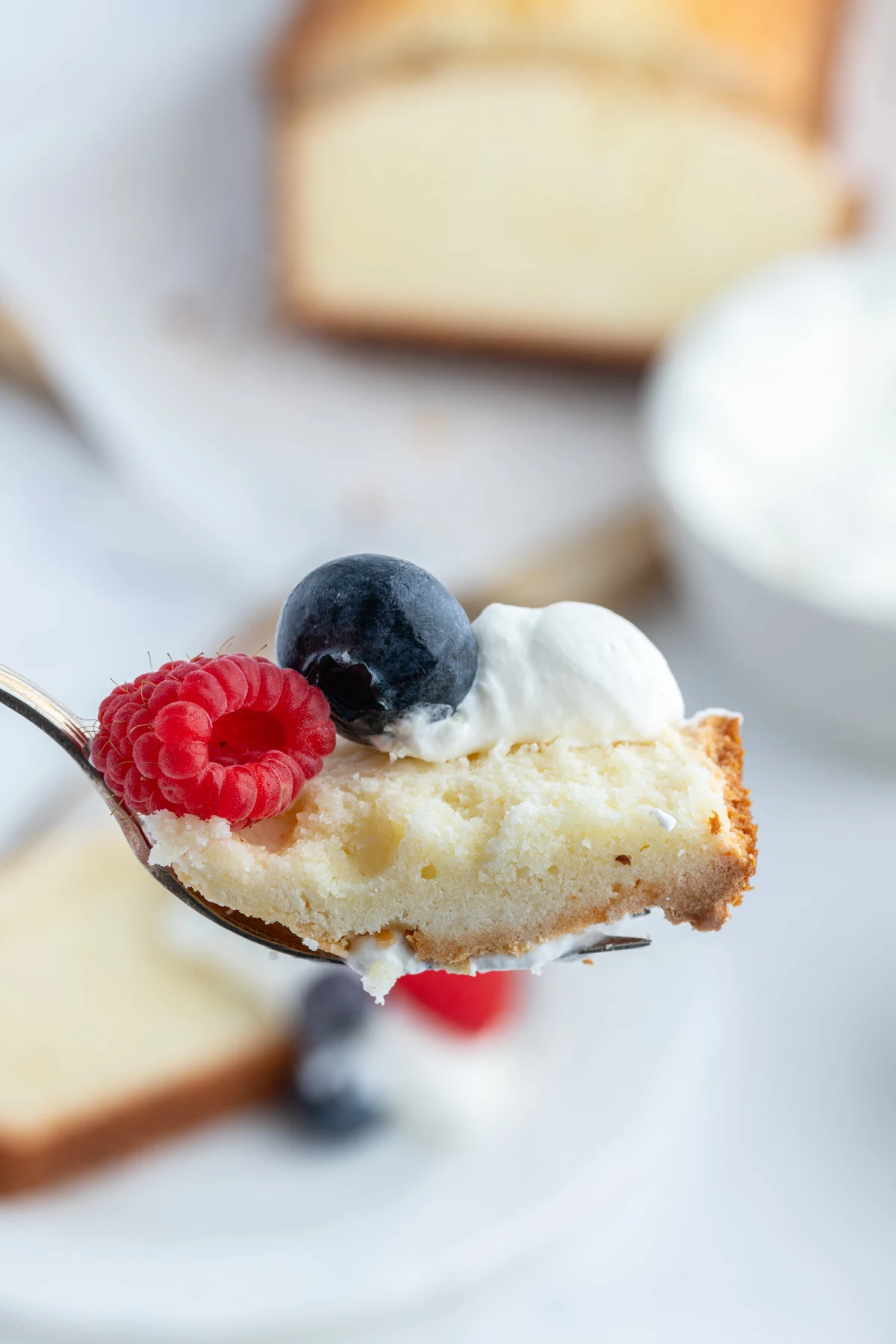 fork full of pound cake with whipped cream and fruit